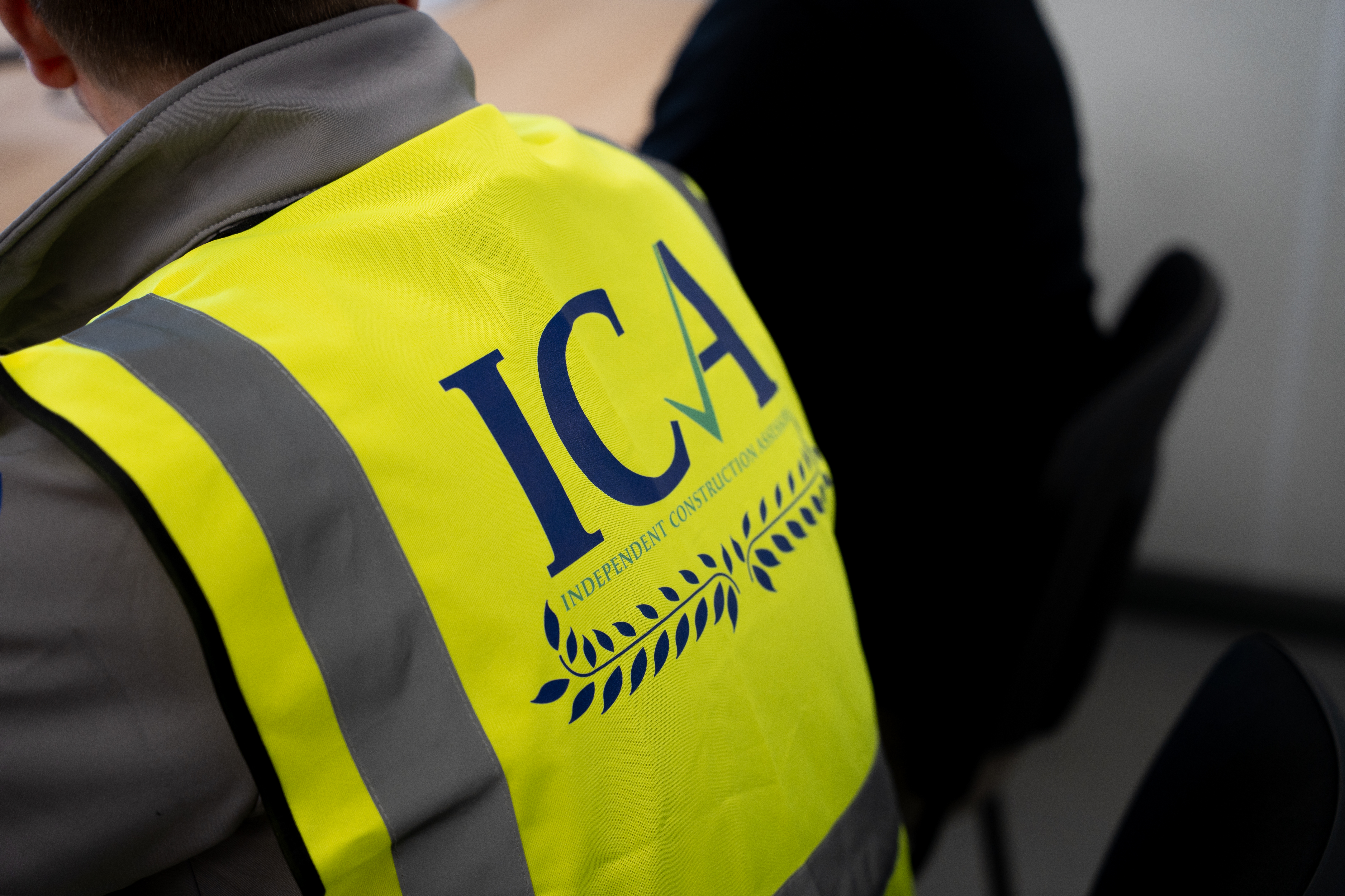 Team member wearing a high-visibility vest with the Independent Construction Assessors logo